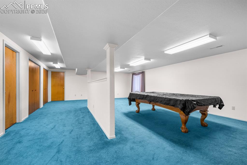 Image 24 of 38: Recreation room with carpet floors and billiards