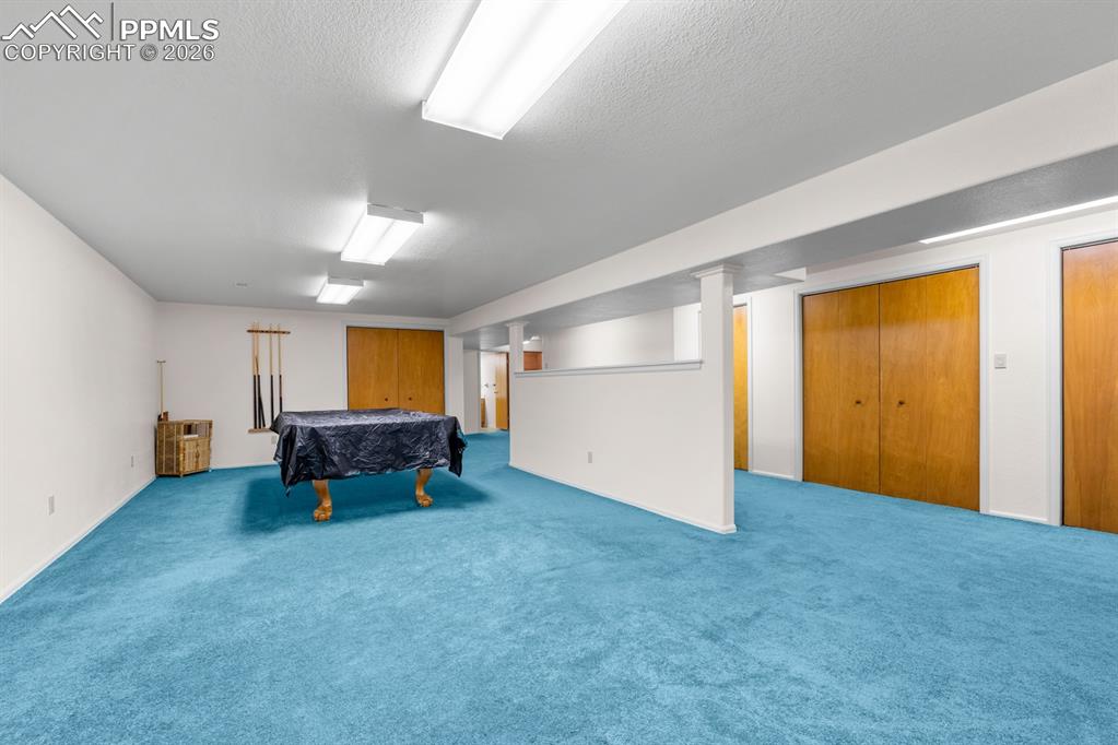 Image 25 of 38: Playroom featuring billiards, carpet flooring, and a textured ceiling