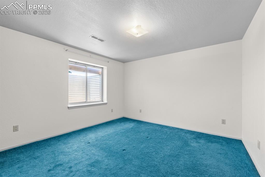 Image 26 of 38: Carpeted spare room featuring a textured ceiling and baseboards