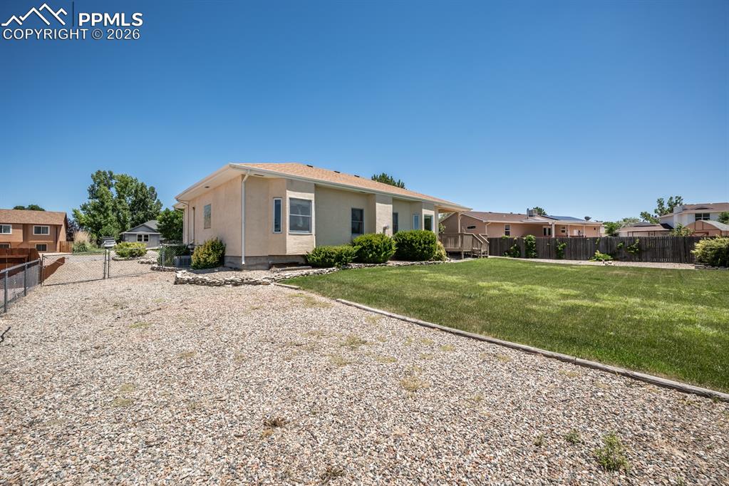 Image 36 of 38: Back of property with stucco siding and a residential view