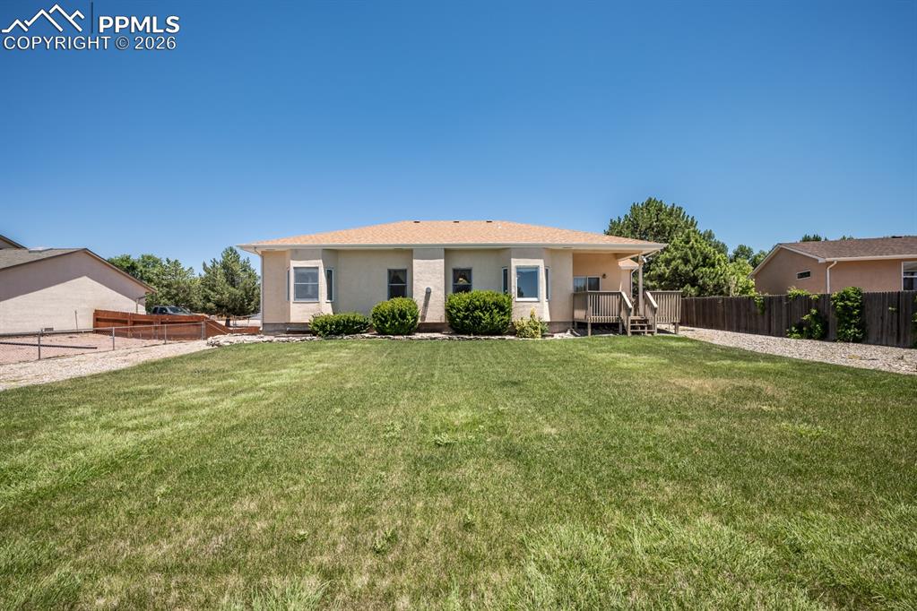 Image 38 of 38: Back of house featuring a wooden deck and stucco siding