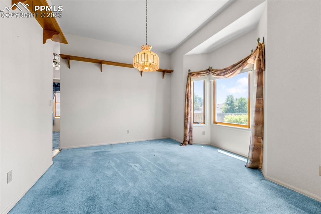 Image 6 of 38: Carpeted empty room featuring baseboards and hanging lights