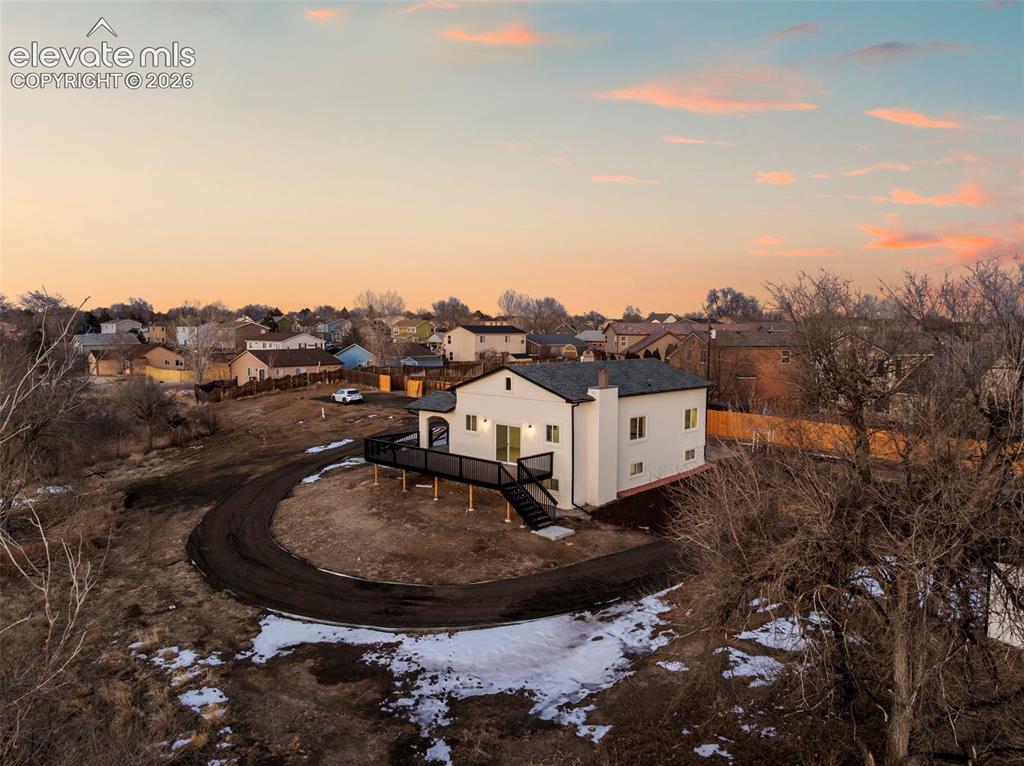 Image 2 of 49: Contemporary residence with a spacious elevated deck, featuring a neutral f