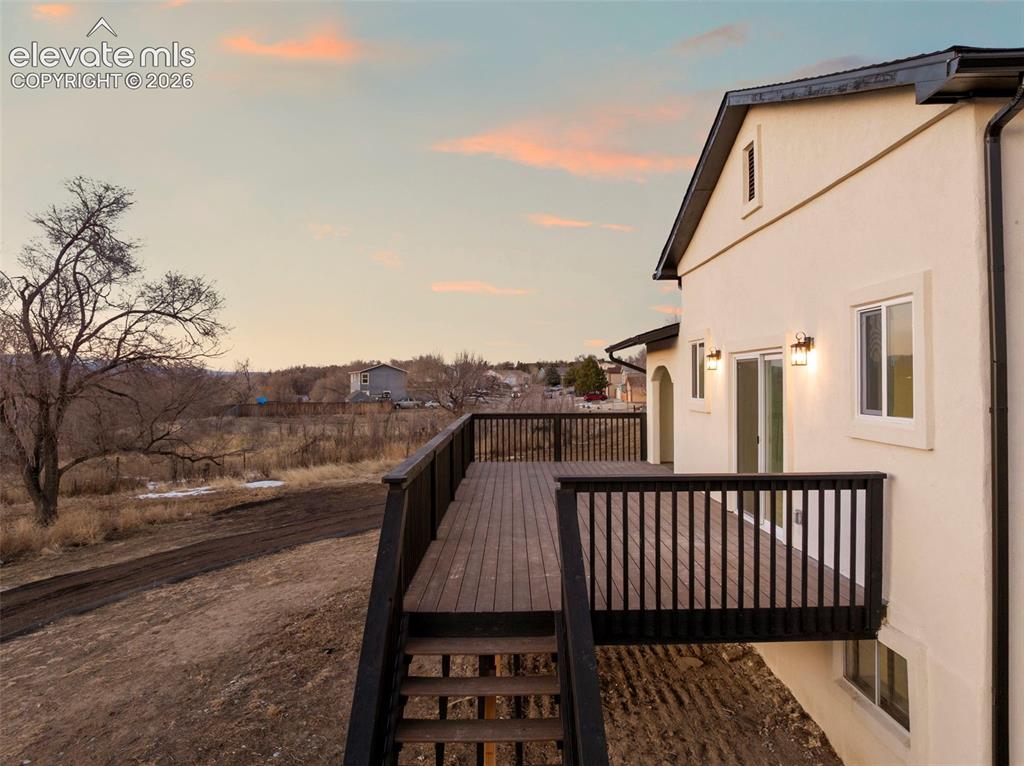 Image 4 of 49: Expansive outdoor deck with dark wood-finish flooring and black railing