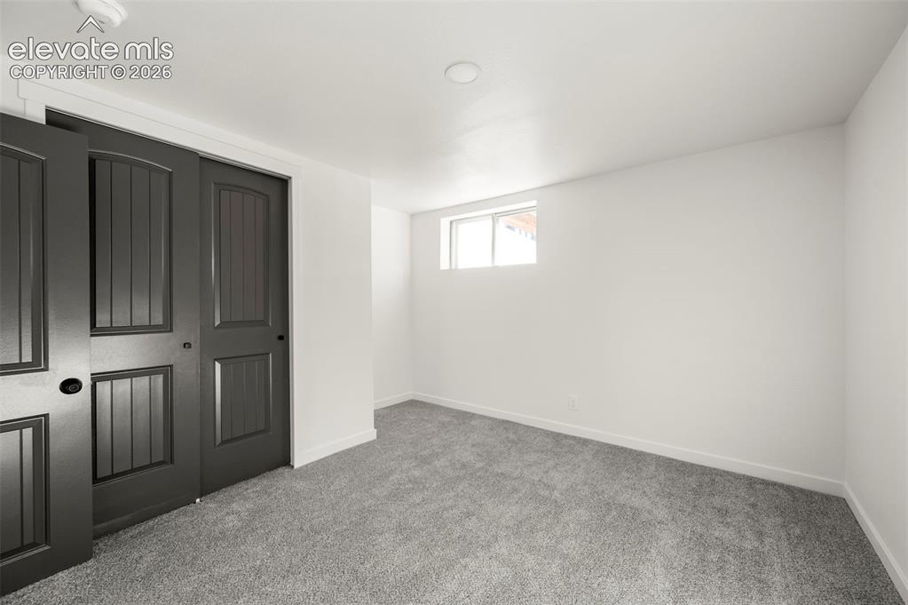 Image 40 of 49: Interior space featuring textured gray carpeting, white walls, and a window