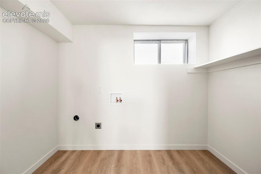 Image 44 of 49: Laundry area featuring wood-finish flooring, a utility sink hookup, and a w