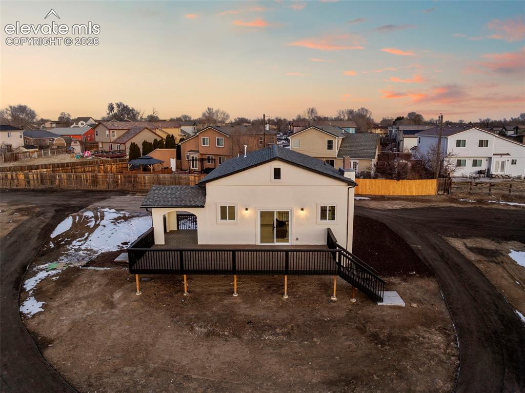 Image 7 of 49: Exterior featuring a spacious elevated deck with dark railings and steps