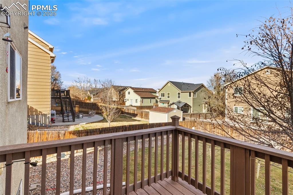 Image 11 of 33: Deck with a residential view, a fenced backyard, a shed, and stairway