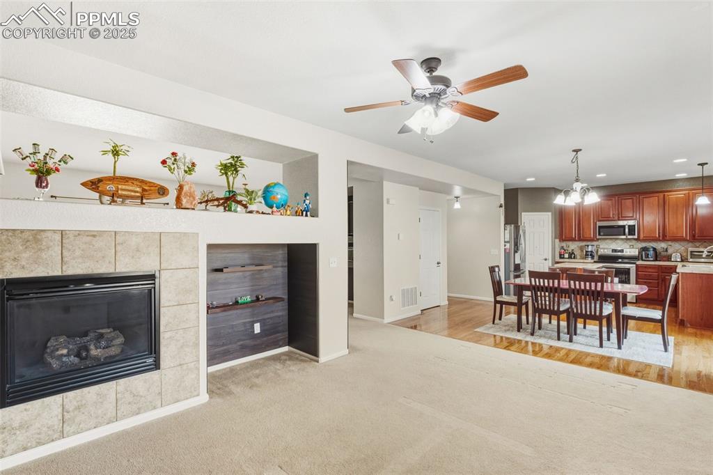 Image 12 of 33: Living room with a chandelier, a tile fireplace, recessed lighting, ceiling