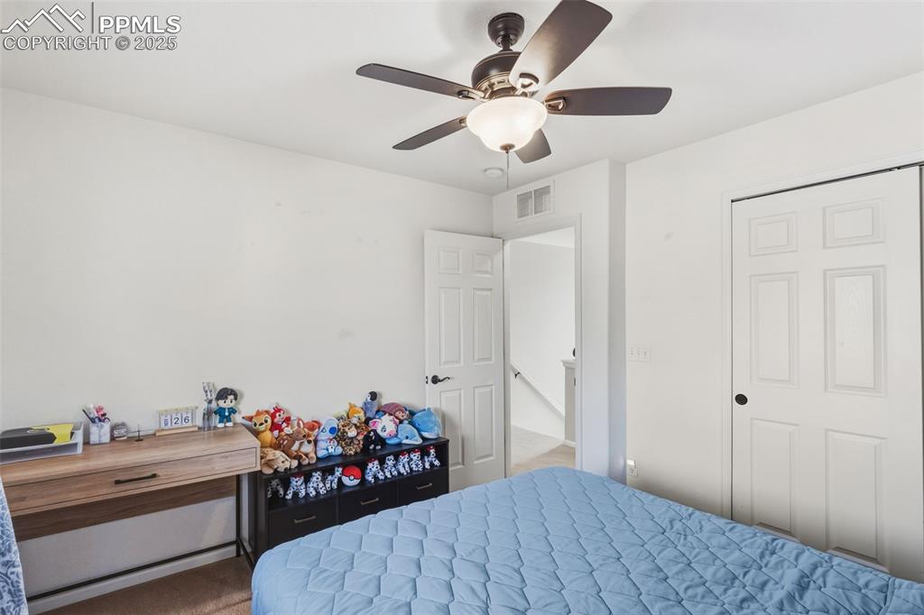 Image 20 of 33: Carpeted bedroom featuring a ceiling fan and a closet