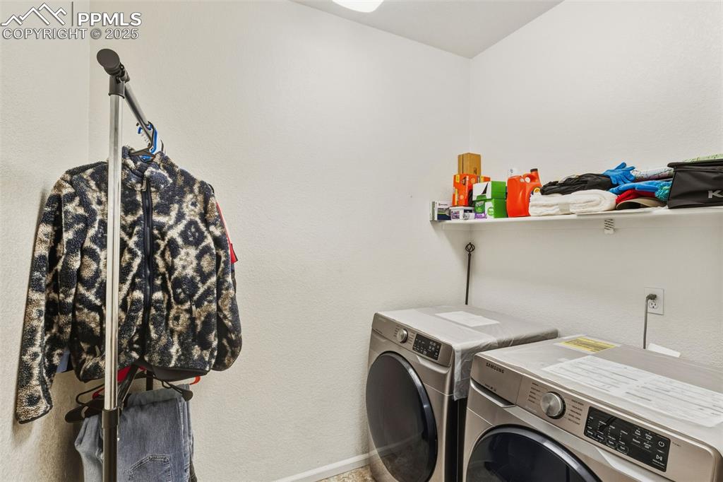 Image 22 of 33: Washroom featuring washing machine and dryer and a textured wall