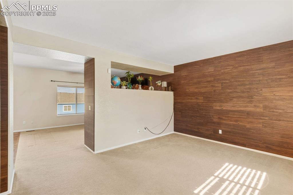 Image 6 of 33: Empty room with wooden walls and carpet