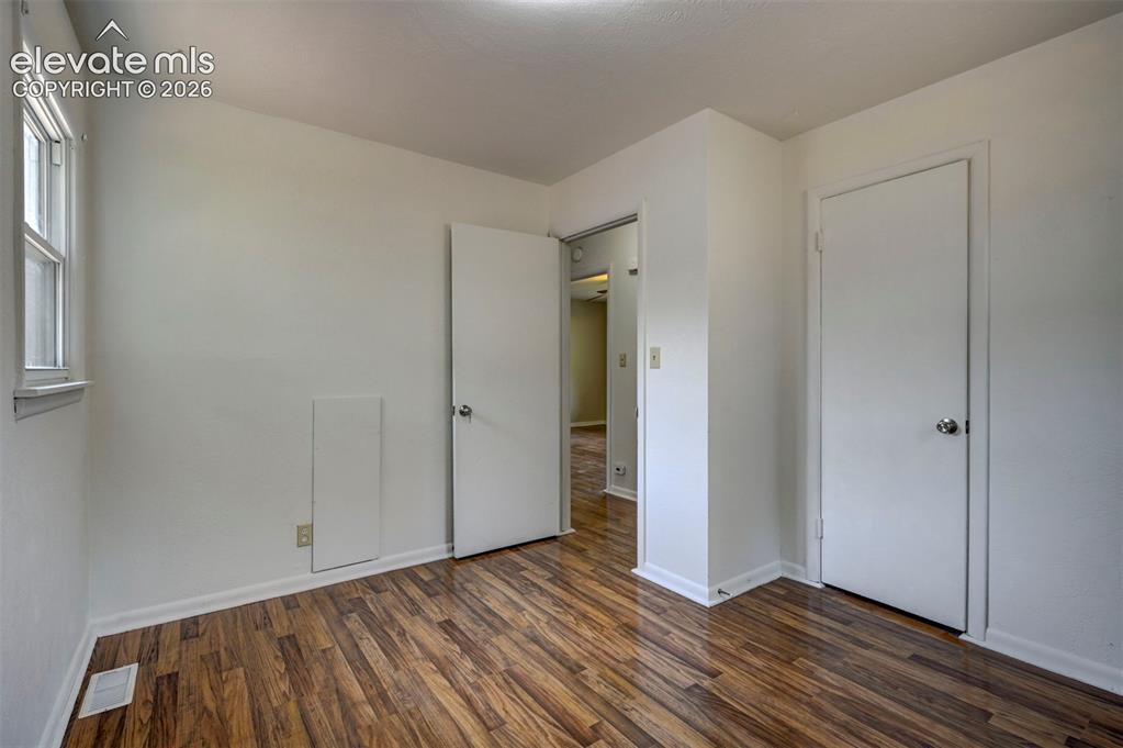 Image 30 of 40: Room featuring wood-finish flooring, white baseboards, and a white interior