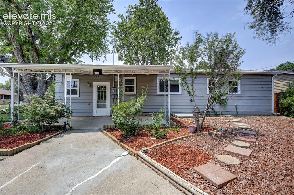 Image 32 of 40: Exterior featuring gray siding, a covered entry, and mature trees