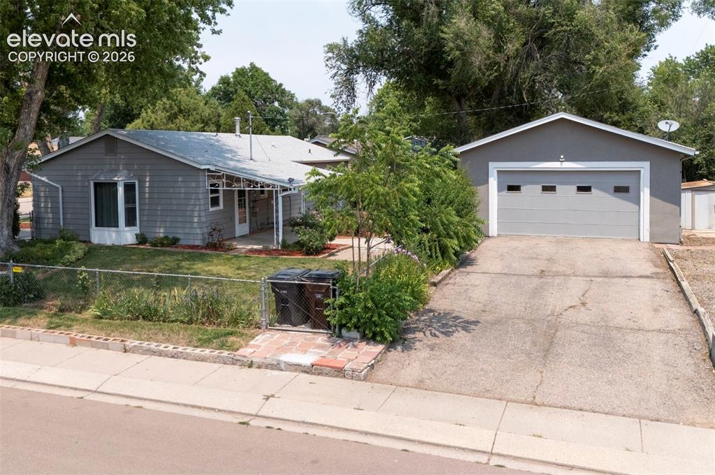 Image 36 of 40: Single-story residence featuring gray siding and a front lawn with mature t