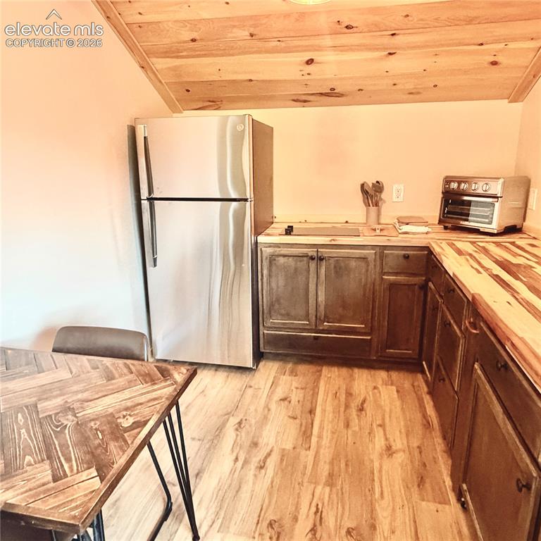 Image 11 of 45: Stainless steel refrigerator, custom wood cabinetry, butcher block countert