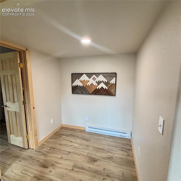 Image 20 of 45: Wood-finish flooring, recessed ceiling lighting, and natural wood trim deta