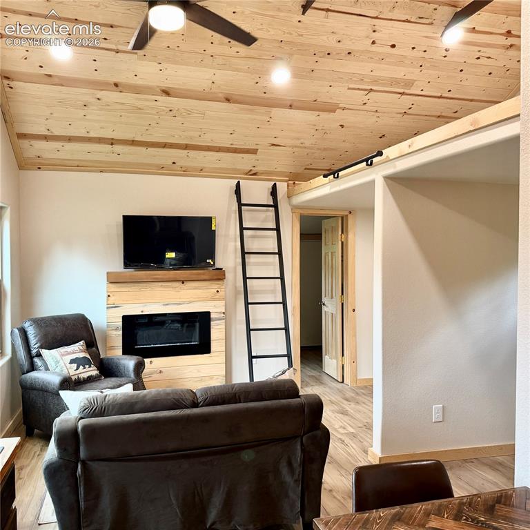 Image 5 of 45: Wood-finish ceiling with integrated lighting and ceiling fans