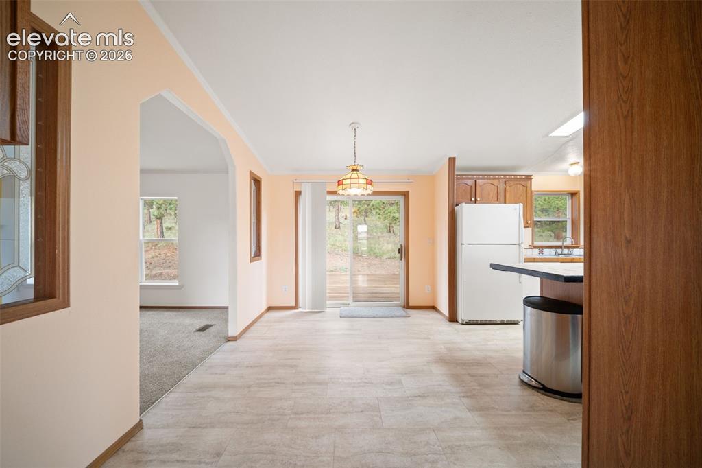 Image 13 of 40: Informal dining room leading to back deck