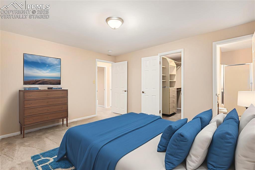 Image 13 of 29: Virtually Staged. Bedroom featuring light colored carpet and a spacious clo