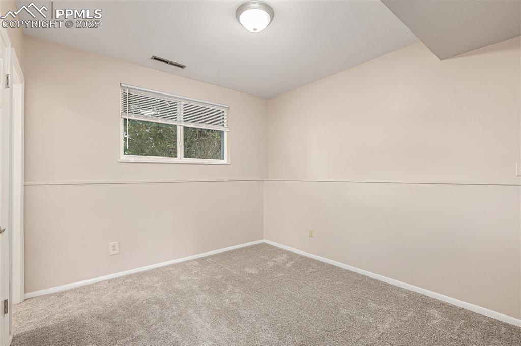 Image 21 of 29: Spare bedroom featuring newly carpeted floors