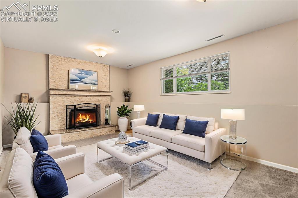 Image 23 of 29: Virtually Staged. Newly carpeted family room featuring a fireplace