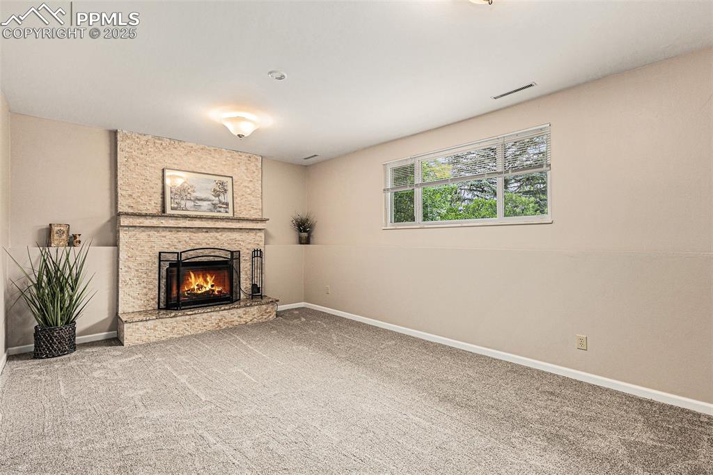 Image 24 of 29: Family room with newly carpeted flooring and a fireplace