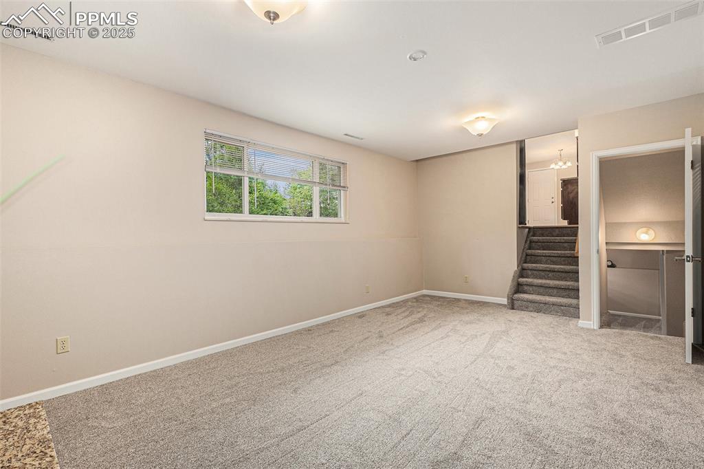 Image 25 of 29: Family room featuring newly carpeted floors and stairway to kitchen