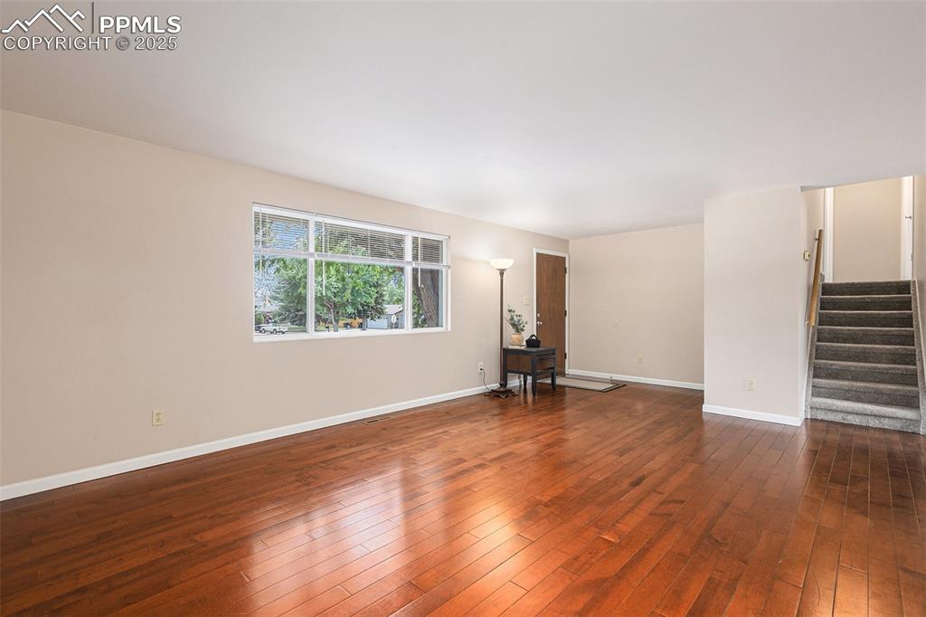 Image 4 of 29: Living room with stairway and dark wood finished floors