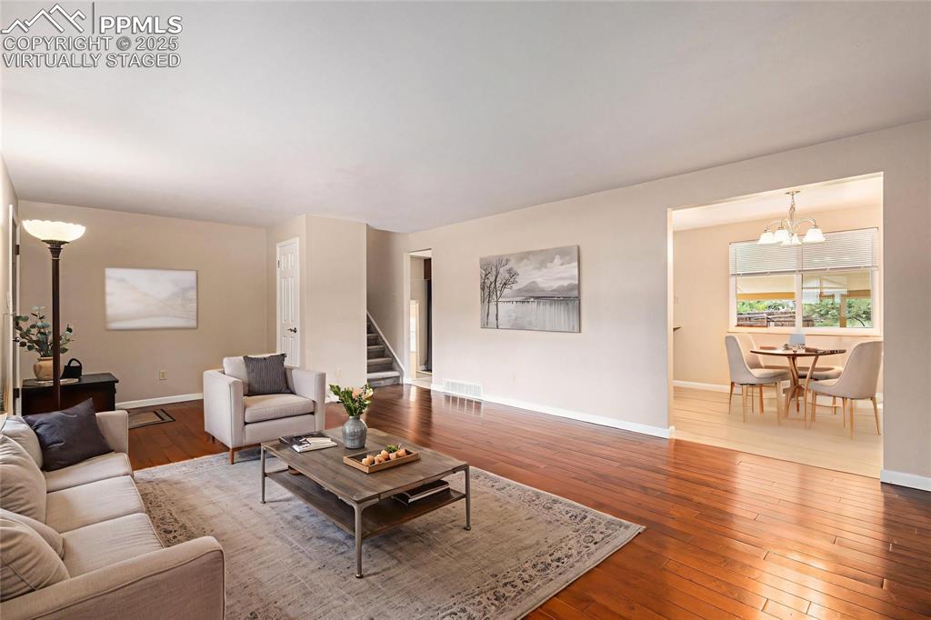 Image 5 of 29: Virtually Staged. Living room featuring hardwood / wood-style floors and st