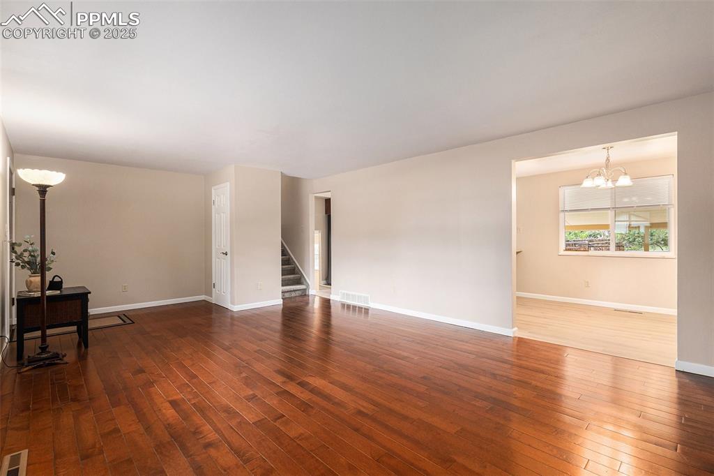 Image 6 of 29: Living room with wood-type flooring and stairs