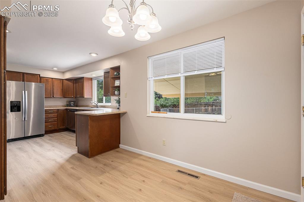 Image 7 of 29: Kitchen featuring stainless steel appliances, a peninsula, light wood-style