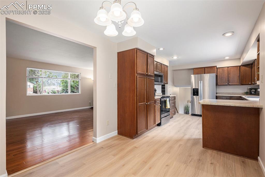 Image 8 of 29: Kitchen featuring light LVP floors, appliances with stainless steel finishe