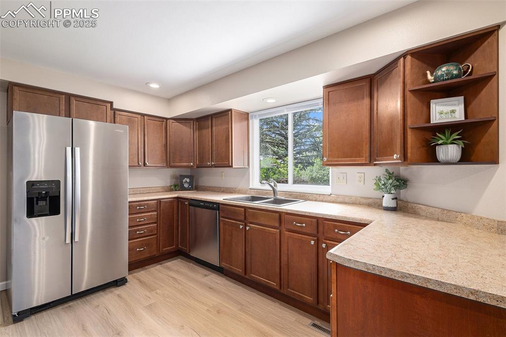 Image 9 of 29: Kitchen featuring appliances with stainless steel finishes, light wood colo