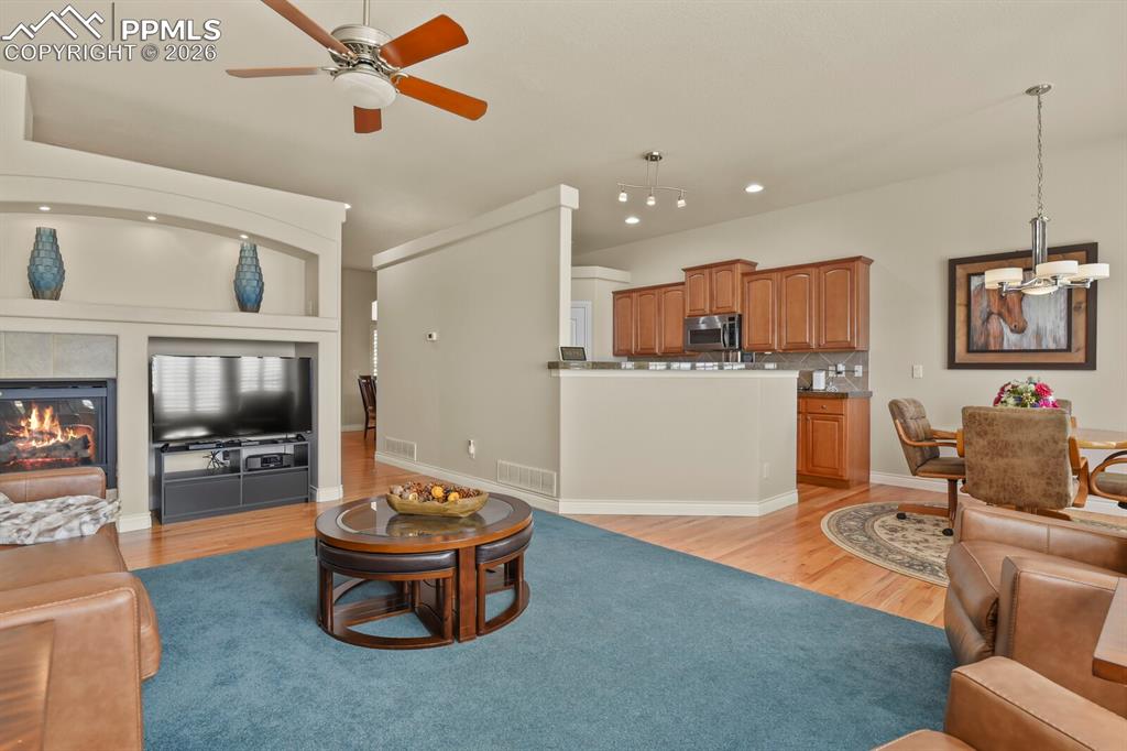 Image 11 of 46: This inviting open plan living area features a fireplace with a tiled surro