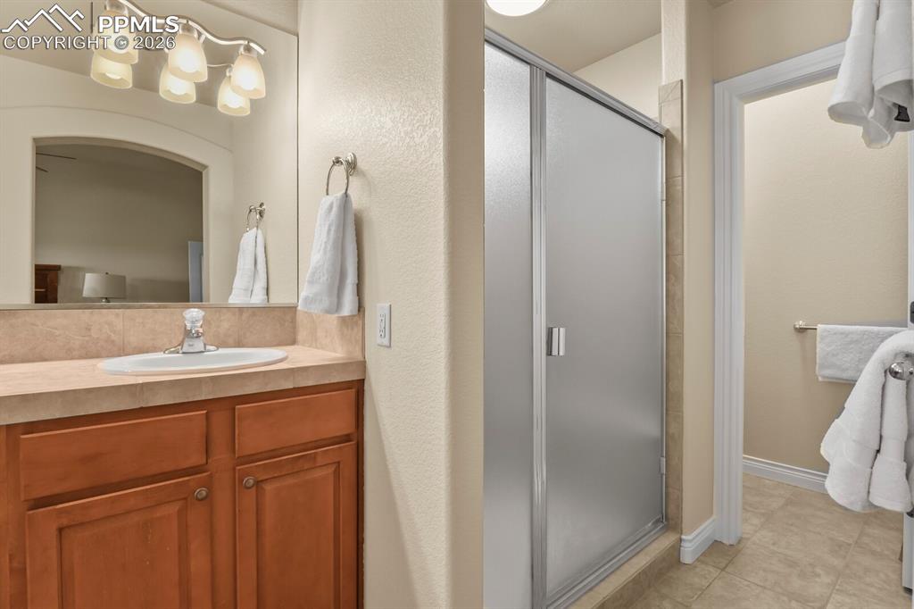 Image 19 of 46: Featuring a double vanity, wooden cabinetry, a separate large shower and th