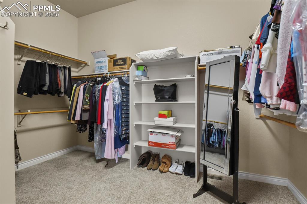 Image 21 of 46: The property includes a spacious walk-in closet featuring built-in shelving