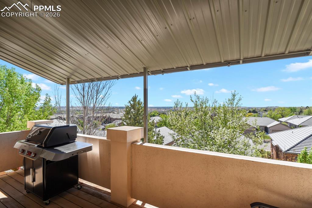 Image 38 of 46: Outdoor living area featuring a covered patio, a stone half-wall, and sceni