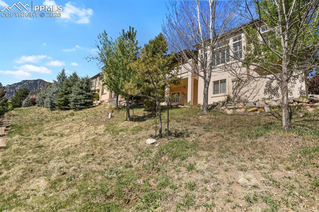 Image 41 of 46: Showing the back of this spacious stucco ranch home. Some mountain views.