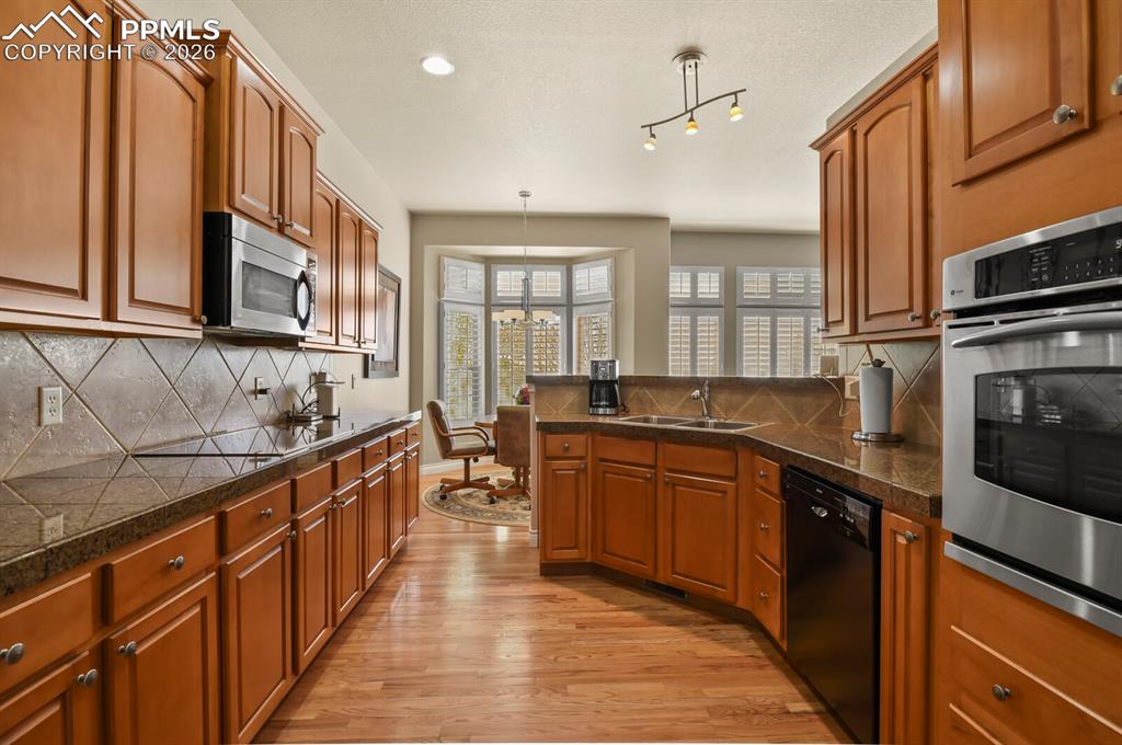 Image 7 of 46: The kitchen features abundant wood cabinetry, stainless steel appliances in