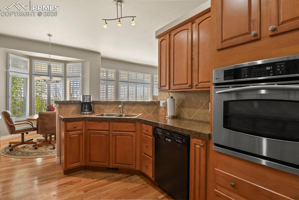 Image 9 of 46: The kitchen features wood cabinetry, a built-in oven,  double stainless ste