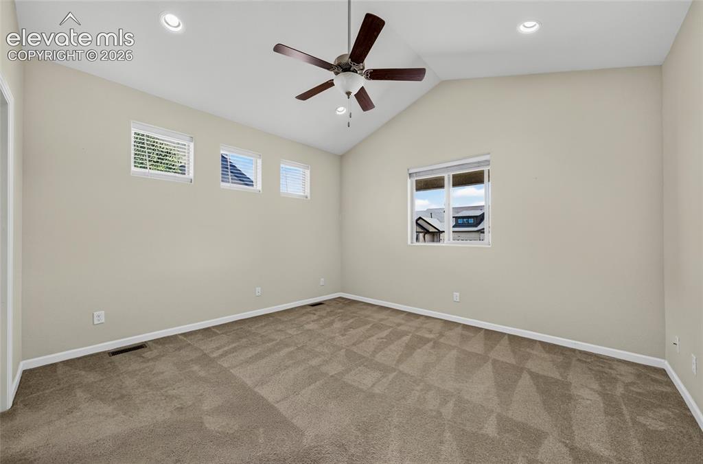 Image 21 of 43: Primary bedroom with valuted celings.