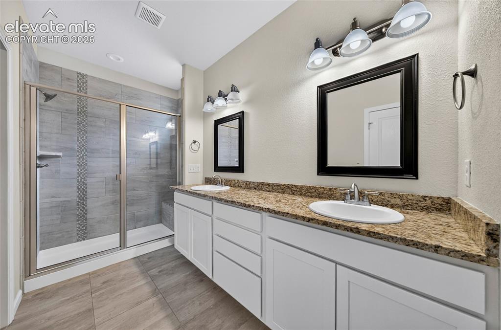 Image 23 of 43: Bright primary bathroom features a generous vanity with ample counter space
