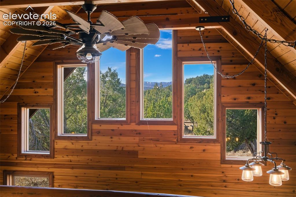Image 16 of 40: Vaulted wood-paneled ceiling with exposed beams, multiple windows, large ce