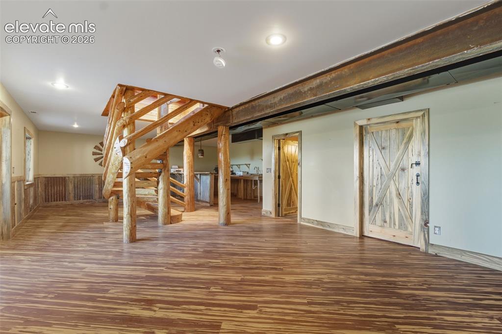 Image 21 of 40: Wood-finish flooring throughout, featuring a custom wood staircase, exposed