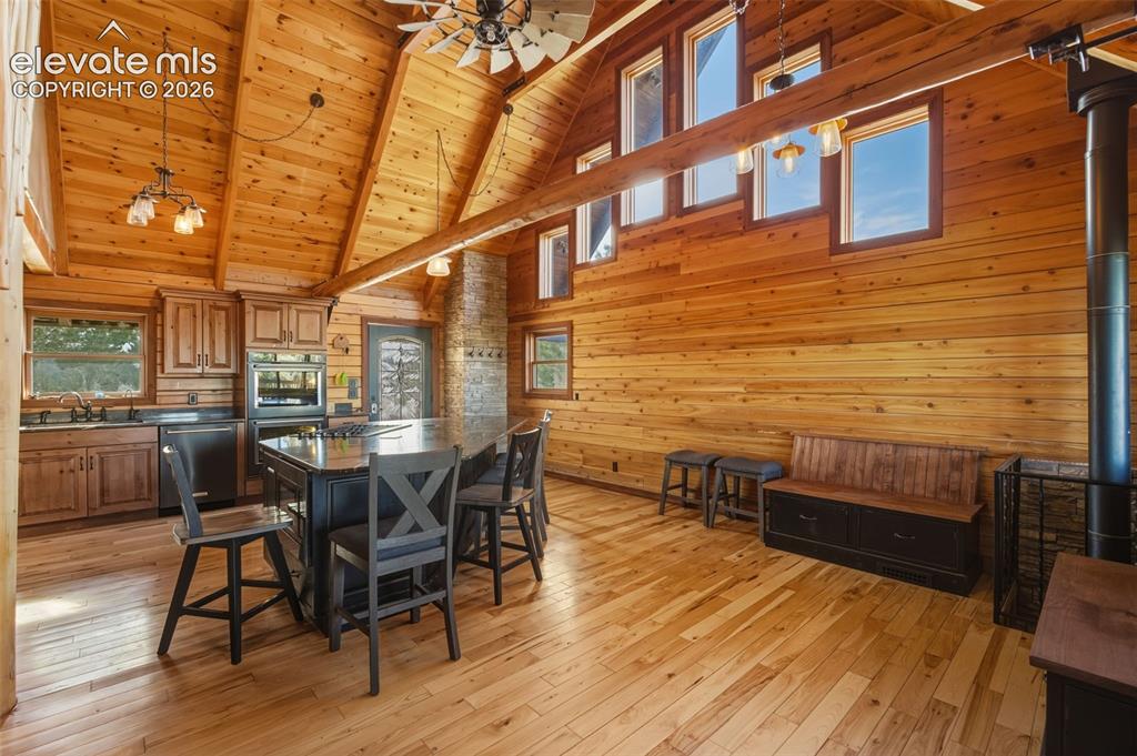Image 24 of 43: Vaulted wood-paneled ceilings, natural wood-finish walls and flooring, kitc