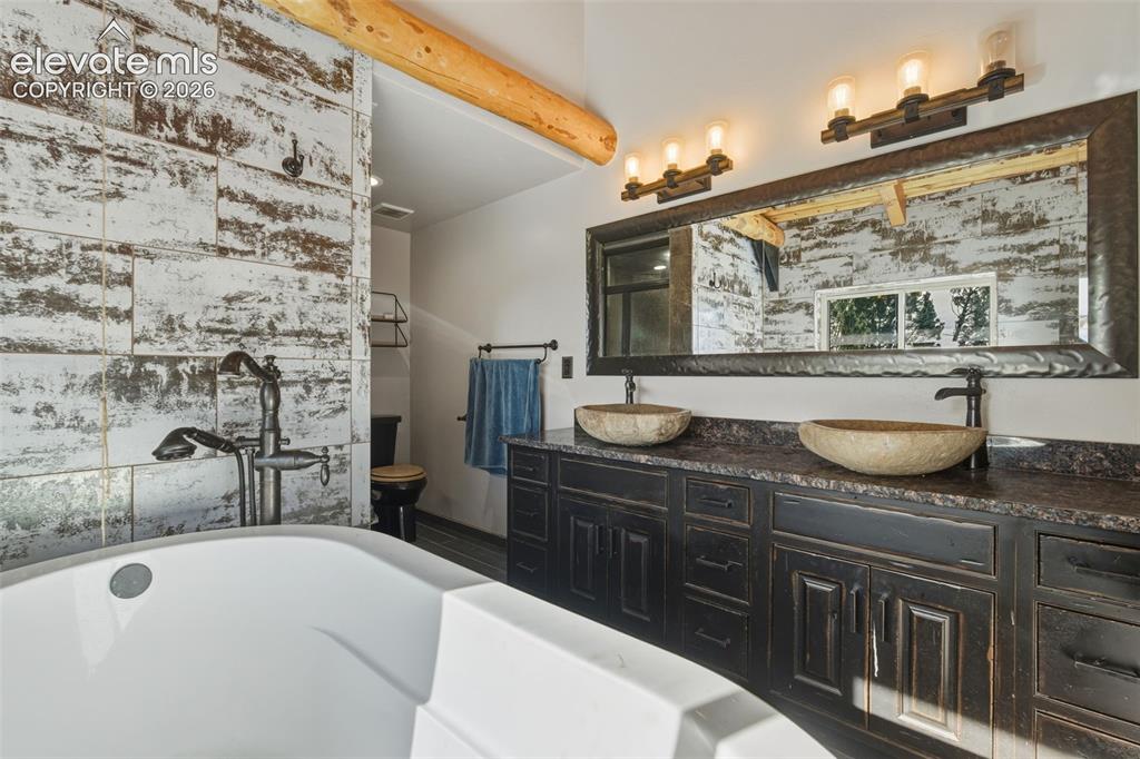 Image 31 of 43: Freestanding soaking tub with a floor-mounted faucet