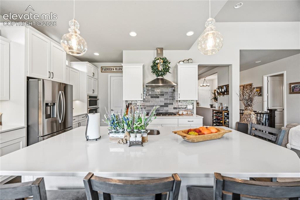 Image 10 of 50: Spacious kitchen island featuring a light-toned countertop and recessed sin