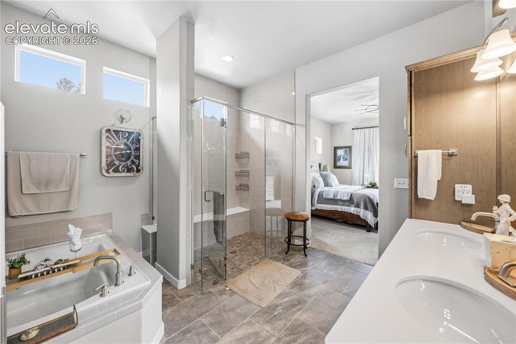 Image 19 of 50: Spacious bathroom featuring a built-in soaking tub, a large glass-enclosed