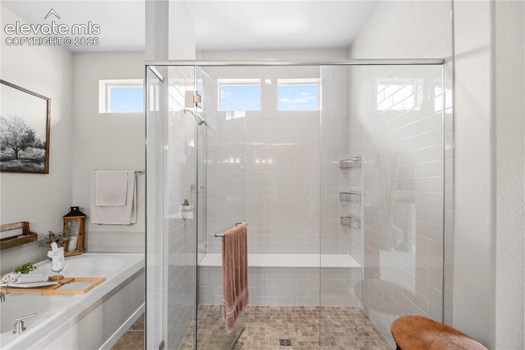 Image 21 of 50: Spacious walk-in shower featuring a glass enclosure, subway tile surround,